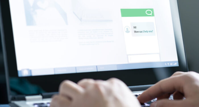 Chatbot or live chat with customer help assistant on business website. AI technology and conversation with automated messages. Client care and service. Online support and helpdesk on laptop screen.